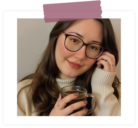 Foto de Gabi Viscki, sorrindo levemente, usando óculos de grau e suéter claro, segurando uma caneca de café, com moldura branca e fita adesiva decorativa roxa no topo.